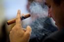 A delegate uses an e-cigar during "The E-Cigarette Summit" at the Royal Academy in central London on November 12, 2013