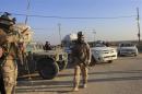Iraqi soldiers stand guard at a checkpoint in Ein Tamarm