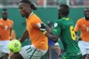 Ivory Coast's forward and captain Didier Drogba (L) fights for the ball with Senegal's defender Lamine Sane (R) during their FIFA 2014 World Cup qualifying football match at the Felix Houphouet-Boigny stadium in Abidjan on October 12, 2013