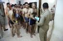 Iraqi men line up for physical examinations at the main army recruiting center to volunteer for military service in Baghdad, Iraq, Tuesday, June 24, 2014, after authorities urged Iraqis to help battle insurgents. Political leaders have agreed to start the process of seating a new government by July 1. Once a stable government is in place, officials hope Iraqi security forces will be inspired to fight the insurgency instead of fleeing, as they did in several major cities and towns in Sunni-dominated areas since the start of the year.(AP Photo/Karim Kadim)