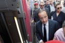France's President Hollande and his companion Trierweiler take a high-speed TGV train at the Gare de Lyon train station in Paris as they depart for their summer holidays