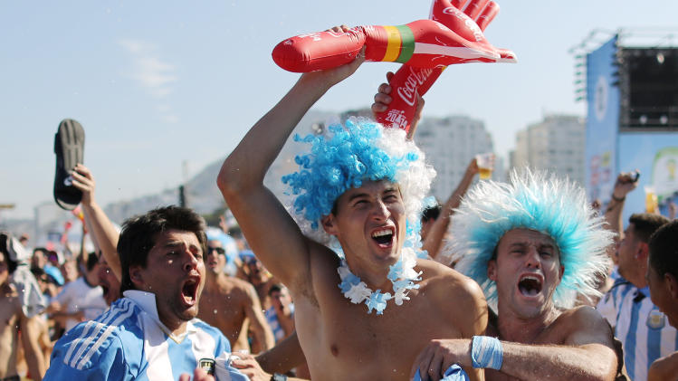 Argentine soccer fans celebrate a goal scored by their side, during the live telecast of the World Cup match between Argentina and Nigeria inside the FIFA Fan Fest area on Copacabana beach, in Rio de Janeiro, Brazil, Wednesday, June 25, 2014. (AP Photo/Leo Correa)