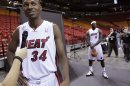 Ray Allen talks to the media as teammate LeBron James poses for a photograph during media day at the Miami Heat's home arena in Miami, Florida