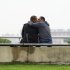 Two men kiss as they sit in a riverside park in New York