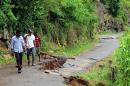 A road damaged after a landslide caused by heavy monsoon rains in Koslanda village in central Sri Lanka on October 30, 2014
