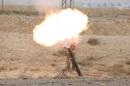 Shiite fighters launch a mortar round toward Islamic State militants in Baiji, north of Baghdad,