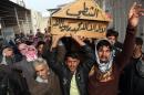 Mourners chant slogans against sectarianism while carrying the coffin of Sheik Adnan Majeed al-Ghanem during his funeral in Basra, Iraq's second-largest city, 340 miles (550 kilometers) southeast of Baghdad, Iraq, Wednesday, Nov. 27, 2013. The Sunni Arab tribal sheik was kidnapped along with another Sunni, Sheik Kadim al-Jubouri about a month ago in Basra and their bodies were discovered Tuesday, their families said. (AP Photo/Nabil al-Jurani)
