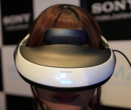 A model wears a 60,000 yen ($800) HMZ personal 3-D viewer during a news conference at Sony headquarters in Tokyo Wednesday, Aug. 31, 2011. Sony Corp. says it will start selling a head mounted display that provides a 3-D theater of music videos, movies and games, targeting people who prefer solitary entertainment rather than sitting in front of a TV with family or friends. (AP Photo/Itsuo Inouye)