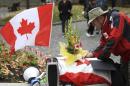 A man writes in books of condolences to fallen Canadian soldiers, Warrant Officer Patrice Vincent and Corporal Nathan Cirillo, during a vigil in Montreal