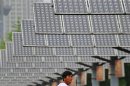 A man eats his breakfast as he walks under solar panels belonging to a solar power plant in Shenyang