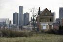In a photo from Monday, Dec. 2, 2013, an empty field in Brush Park, north of Detroit's downtown is shown with an abandoned home. Detroit, which on Thursday, July 18, 2013, filed the largest municipal bankruptcy case in American history, owes as much as $20 billion to banks, bondholders and pension funds. The city can get rid of its gargantuan debt, but a bankruptcy judge can't bring back residents or raise its dwindling revenue. (AP Photo/Carlos Osorio, File)