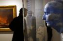 A visitor looks at a Rene Magritte sculpture "L'avenir des Statues" made with Napoleon's death mask during a press visit of the exhibition "Napoleon in St Helena" in Paris, France, Tuesday, April 5, 2016. France's national army museum "Les Invalides" has recreated the home where Napoleon lived his final years, bringing furniture and belongings from the remote Atlantic Island of St. Helena to central Paris for the first time since he was exiled there 200 years ago. (AP Photo/Francois Mori)