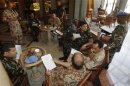 Members of the United Nations observers mission in Syria, who have left their bases in the province of Homs in Central Syria, check their departure dates in a hotel in Damascus