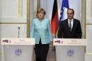 French President Hollande and German Chancellor Merkel arrive at a joint statement at the Elysee Palace in Paris