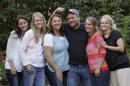 FILE - In this Sept. 11, 2013, file photo, Brady Williams poses with his wives, from left to right, Paulie, Robyn, Rosemary, Nonie, and Rhonda, outside of their home in a polygamous community outside Salt Lake City. The newest polygamous family from Utah on reality TV says sharing their story with a wide audience has been liberating. The first of nine episodes chronicling the life of Williams, his five wives and their 24 children airs Sunday on TLC. A pilot episode aired last fall of the show, being called "My Five Wives." Williams and his wives said in an interview with The Associated Press that they enjoy being able live openly and not worry about who knows about their lifestyle. (AP Photo/Rick Bowmer, File)