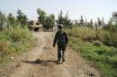 A picture released by the official Syrian Arab News Agency (SANA) shows a Syrian soldier walking in a road in the northwestern countryside of Hama on October 15, 2015