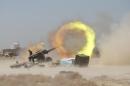 An Iraqi Shi'ite fighter fires artillery during clashes with Islamic State militants near Falluja