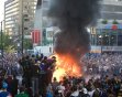 People watch a car burn following Game 7 of the NHL hockey Stanley Cup Finals on Wednesday, June 15, 2011, in Vancouver, British Columbia. Parked cars were set on fire, others were tipped over and peo