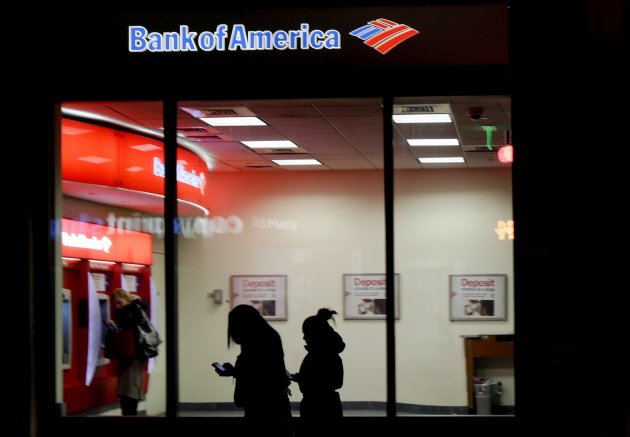 In this Thursday, Dec. 13, 2012 photo people use a Bank of America ATM in Boston. Banks including JPMorgan Chase, U.S. Bancorp and Bank of America seized on government payments for unemployment compensation as a business opportunity and pitched card programs to many states. However to cover the costs of the programs, banks have hit all card users with a plethora of new fees. (AP Photo/Charles Krupa)