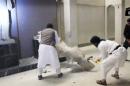 In this image made from video posted on a social media account affiliated with the Islamic State group on Thursday, Feb. 26, 2015, which has been verified and is consistent with other AP reporting, militants take sledgehammers to an ancient artifact in the Ninevah Museum in Mosul, Iraq. The extremist group has destroyed a number of shrines --including Muslim holy sites -- in order to eliminate what it views as heresy. The militants are also believed to have sold ancient artifacts on the black market in order to finance their bloody campaign across the region. (AP Photo via militant social media account)