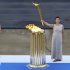 An actress at the role of the high priestess holds the Olympic torch during a ceremony in Athens