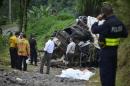 Policemen and rescue officials check the site where a bus plunged off a steep road killing 11 and injuring 12 in Heredia, Vara Blanca, Costa Rica on October 20, 2016