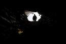 An Iraqi federal police officer stands outside a tunnel, which was used by Islamic State militants, in Mosul
