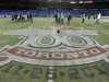Toronto Argonauts players are interviewed on the field behind the Grey Cup logo during practice ahead of the 100th Grey Cup CFL football game in Toronto