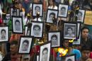 Family members of 43 missing teachers college students carry pictures of the students as they march with supporters to demand the case not be closed and that experts' recommendations about new leads be followed, in Mexico City, Tuesday, April 26, 2016. The U.N. Office of the High Commissioner for Human Rights said Tuesday that it is troubled by a group of international experts' complaints of obstacles to their investigation into Sept. 26, 2014 disappearance of the students in southern Guerrero State.(AP Photo/Rebecca Blackwell)