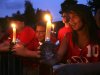 Lilian Sanchez and her brother Chuck Donahue stand beside their father Charles Donahue Jr., left, as striking Verizon workers picket and hold a candle light vigil at the home of Verizon CEO Lowell McAdam in Mendham, N.J., Thursday, Aug. 18, 2011. (AP Photo/Rich Schultz)
