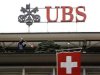 A Switzerland's national flag flies in front of the logo of Swiss bank UBS at the company's headquarters in Zurich