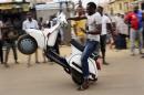 A man pulls a wheelie on a scooter, as residents celebrate the anticipated victory of Presidential candidate Muhammadu Buhari in Kaduna, Nigeria, Tuesday, March 31, 2015. Former military dictator Muhammadu Buhari has won Nigeria's presidential election but fears his victory could be stolen by 