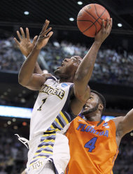 Marquette's Darius Johnson-Odom (1) takes aim as Florida's Patric Young (4) defends during the first half of a NCAA tournament West Regional semifinal college basketball game Thursday, March 22, 2012, in Phoenix. (AP Photo/Chris Carlson)