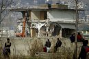Local residents watch as authorities use heavy machinery to demolish the compound of Osama bin Laden in Abbottabad, Pakistan on Sunday, Feb. 26, 2012. Pakistan was more than halfway done Sunday demolishing the three-story compound where bin Laden was killed by U.S. commandos last May, erasing a concrete reminder of a painful and embarrassing chapter in the country's history. (AP Photo/Anjum Naveed)
