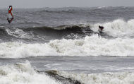 Surfers ride waves at Nishihara beach in Fujisawa, near Tokyo, Saturday, Sept. 3, 2011. Slow-moving Typhoon Talas reached southern Japan, bringing heavy rain and strong winds across a wide swath of the country. (AP Photo/Koji Sasahara)