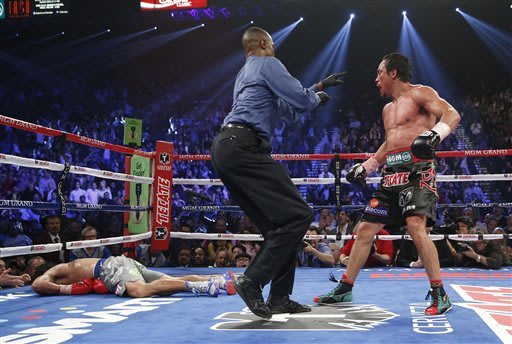 Referee Kenny Bayless, center, sends Juan Manuel Marquez, from Mexico, right, to his corner after Marquez knocked out Manny Pacquiao, from the Philippines, left, in the sixth inning of their WBO world welterweight  fight Saturday, Dec. 8, 2012, in Las Vegas. Marquez won the fight by a knockout.  (AP Photo/Eric Jamison)