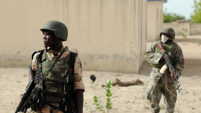 Nigerian soldiers patrol in the north of Borno state close to a Islamist extremist group Boko Haram former camp near Maiduguri on June 8, 2015