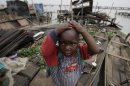 In this photo taken Thursday, July 26, 2012, a child stand in front of his demolished stilt house at Makoko in Lagos, Nigeria. The teeming, floating Makoko slum rises out of the murky lagoon water that separates mainland Nigeria from the island that gave birth to its largest city, a permanent haze of smoke rising from its homes built on timber stilts. A government-led eviction last week that saw men in speedboats destroy homes with machetes there left about 3,000 people homeless and raised new fears among activists that authorities may try to wipe it out the area entirely. (AP Photo/Sunday Alamba)