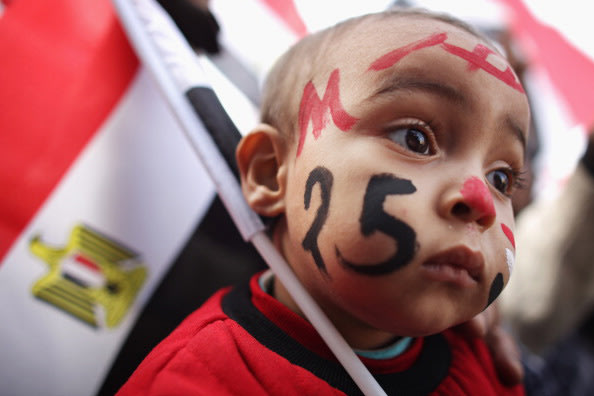 A young child has his face painted with the date twenty five as Egyptians gather in Tahrir Square to mark the one year anniversary of the revolution on January 25, 2012 in Cairo Egypt. Tens of thousan
