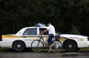 A cyclist speaks with a police officer in Lac Megantic