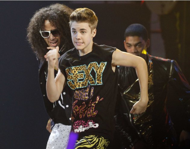 Singer Justin Bieber dances with pop group LMFAO as they perform at the 2011 American Music Awards in Los Angeles