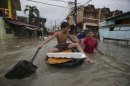 Filipino boys play along a flooded street in Las Pinas, south of Manila, Philippines on Monday, Aug. 19, 2013. Torrential rains brought the Philippine capital to a standstill Monday, submerging some areas in waist-deep floodwaters and making streets impassable to vehicles while thousands of people across coastal and mountainous northern regions fled to emergency shelters. (AP Photo/Aaron Favila)