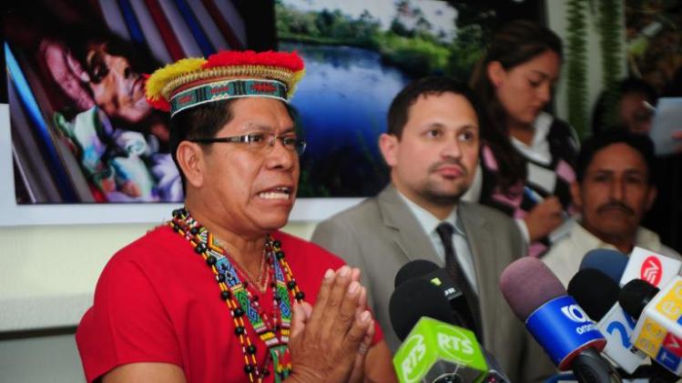 Humberto Piaguaje, representative of Ecuadorean people affected by environment damage caused by Chevron-Texaco in the Amazon basin region, speaks next to the lawyer Juan Pablo Saenz (R) during a press conference in Quito on November 13, 2013