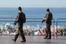 Soldiers patrol past a makeshift memorial in tribute to the victims of the deadly Bastille Day attack at the Promenade des Anglais in Nice