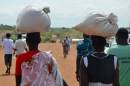 South Sudanese women carry food inside the Protection of Civilians site located at the United Nations Missions in Sudan on September 17, 2014 in Juba