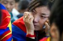 An Tibetan exile cries during a special ceremony to pay homage to 27-year-old Jamphel Yeshi, who passed away Wednesday morning two days after he immolated himself in New Delhi, in Dharmsala, India, Friday, March 30, 2012. Buddhist monks chanted prayers and thousands of Tibetan exiles paid homage Yeshi, who burned himself alive as an act of protest against the visit by China's president, during a special ceremony in Dharmsala. (AP Photo/ Ashwini Bhatia)