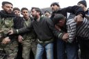 Men mourn, in the presence of Free Syrian Army fighters, the death of two of their relatives killed by what activists said was missiles fired by a Syrian Air Force fighter jet from forces loyal to Syria's President Bashar al-Assad, at the souk of Azaz
