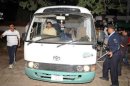 Pakistani policemen escort a minivan carrying family members of slain Al-Qaeda chief Osama bin Laden