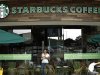 A customer with a cup of coffee leaves the new Starbucks store in San Jose