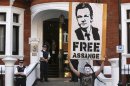 A protestor holds a poster of Wikileaks founder Julian Assange outside Ecuador's embassy in London